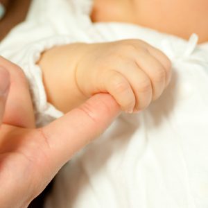 親の指をにぎる赤ちゃん